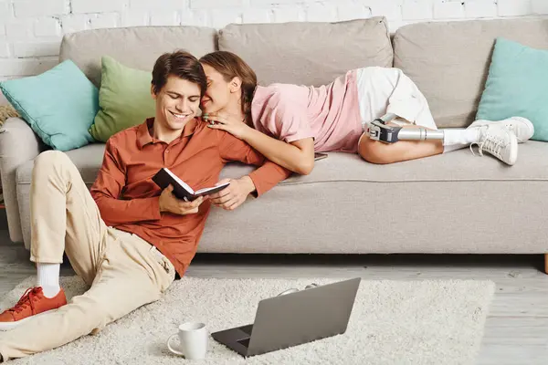 A couple relaxes on a couch, the woman with a prosthetic leg, sharing a moment of intimacy. — Stock Photo