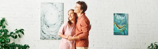 A woman with a prosthetic leg and her boyfriend stand close, admiring a painting in their home. — Stock Photo