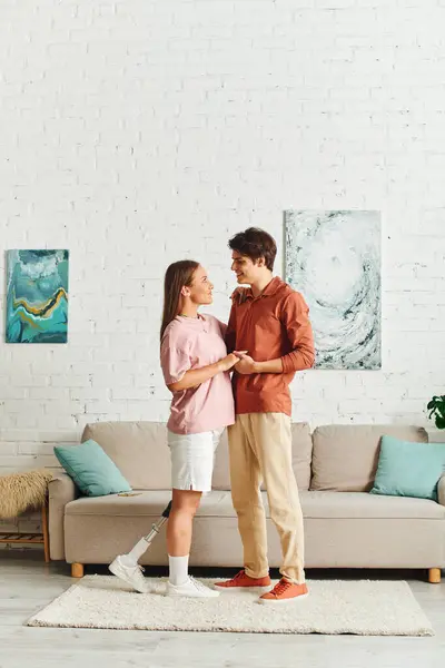 A woman with a prosthetic leg embraces her boyfriend in their home. — Stock Photo