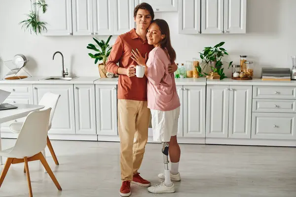 A couple stands in a kitchen, embracing and sharing a moment of intimacy. — Stock Photo
