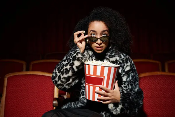 Stilvolle Frau im Kino, Popcorn in der Hand und einen Film anschauen. — Stockfoto