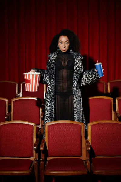 Eine modische Afroamerikanerin im schicken Outfit genießt einen Film im Kino und reagiert mit nachdenklichem Gesichtsausdruck auf den Film. — Stockfoto