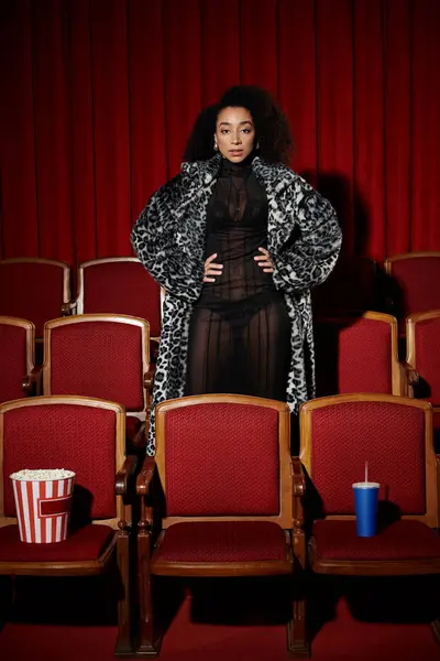 A woman in a stylish fur coat watches a film in a cinema, her expression reflecting the emotions on screen. — Stock Photo