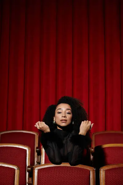 Uma mulher elegante assiste a um filme em um teatro, cativado pela tela. — Fotografia de Stock