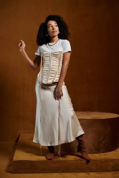 An African American woman in a trendy outfit poses in a studio setting, with a confident and stylish demeanor. — Stock Photo