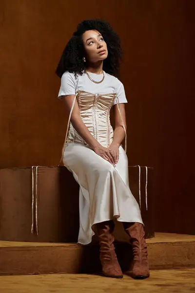 A stylish African American woman in a trendy outfit poses in a studio setting. — Stock Photo