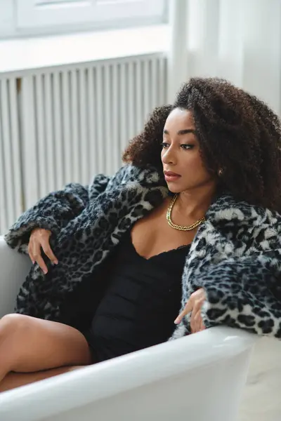 A woman wearing a leopard print coat poses in a studio setting. — Stock Photo