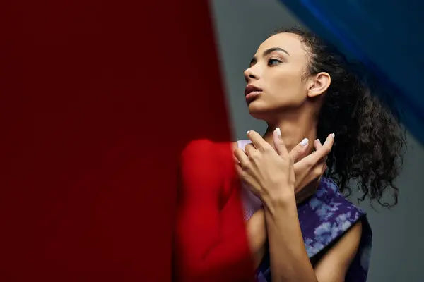 An athletic African American woman poses confidently against colorful glass panels, exuding strength and grace. — Stock Photo