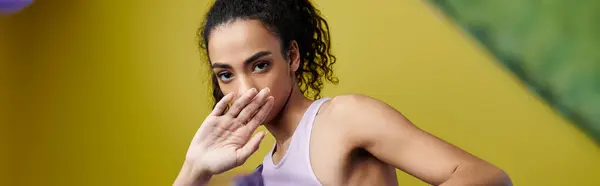 A young woman with curly hair poses in a studio with bright neon lights. — Stock Photo