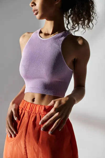 A stylish African American woman poses in a studio with a grey background, showcasing trendy Gen Z fashion. — Stock Photo