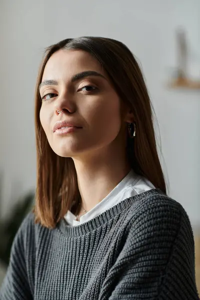 A young woman in a grey sweater works from home, focused and determined, a modern digital nomad. — Stock Photo