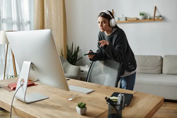 A young woman in a gray sweater works remotely from home, creating content for her digital marketing agency. — Stock Photo