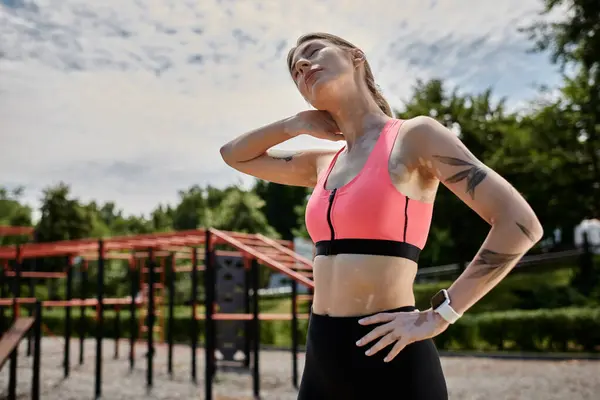 A young woman with vitiligo stretches her neck after exercising outdoors. — Stock Photo