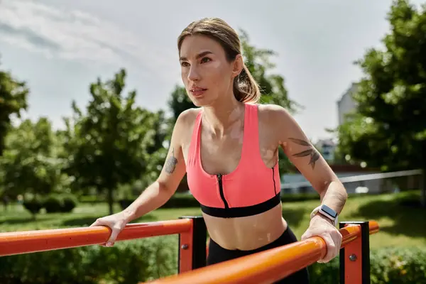 A young sportswoman with vitiligo works out on parallel bars in a park on a sunny day. — Stock Photo