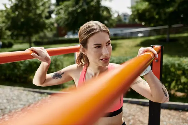 Una joven con vitiligo entrena en un bar en un parque, vistiendo una camiseta deportiva rosa. — Stock Photo