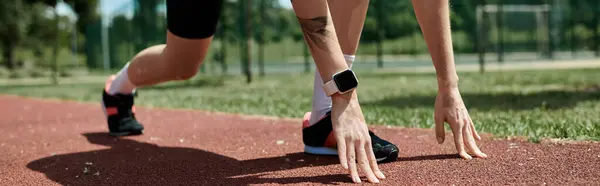 Una giovane donna in abbigliamento attivo si prepara per una gara su una pista rossa. — Foto stock