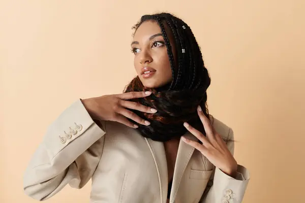 A young woman with stylish braids poses against a neutral background. — Stock Photo