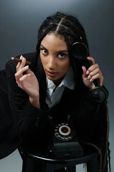 A young woman with braided hair poses with a phone, holding a cigar. — Stock Photo