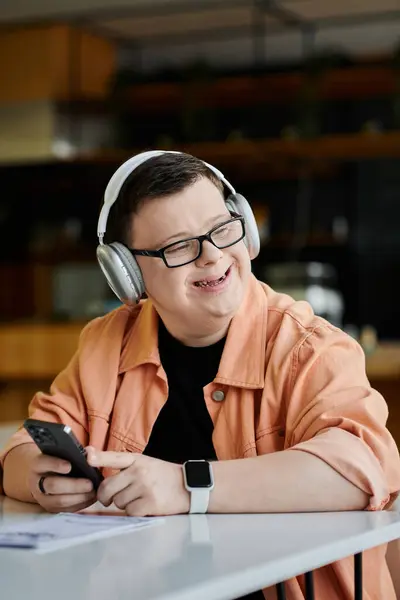 Un hombre con síndrome de Down sonríe mientras trabaja remotamente en un café. — Stock Photo