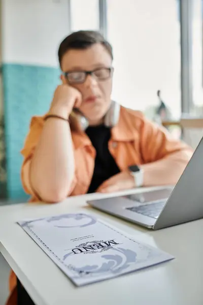 A man with Down syndrome works on his laptop in a cafe, showcasing the increasing diversity of the freelance workforce. — Stock Photo