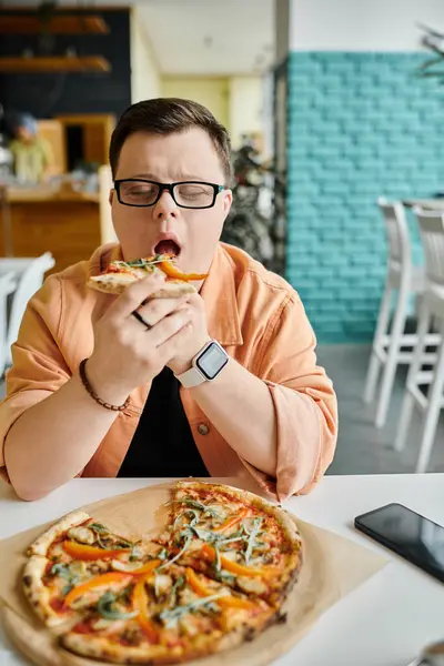 A man enjoys a pizza slice in a cafe, showcasing diversity and inclusion. — Stock Photo
