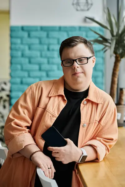 A young man with down syndrome in a cafe, exuding confidence and self-assuredness. — Stock Photo