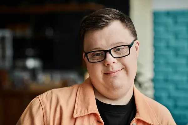 A man with Down syndrome smiles on blue backdrop — Stock Photo