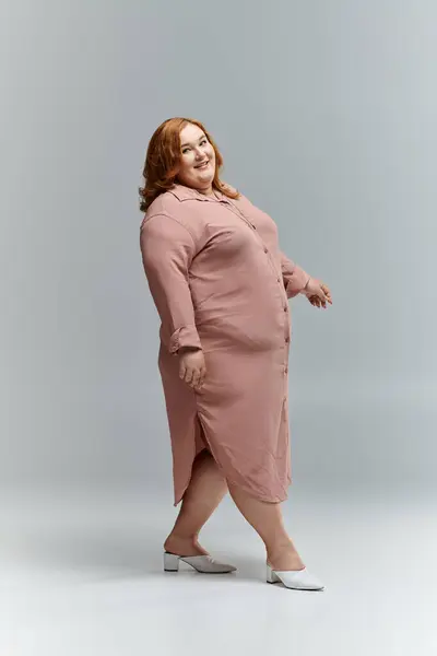 Woman in long pink dress confidently approaches, smiling joyfully — Stock Photo