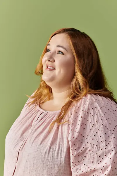 Женщина plus size, одетая в элегантный костюм, смотрит вверх с обнадеживающим выражением лица. — стоковое фото
