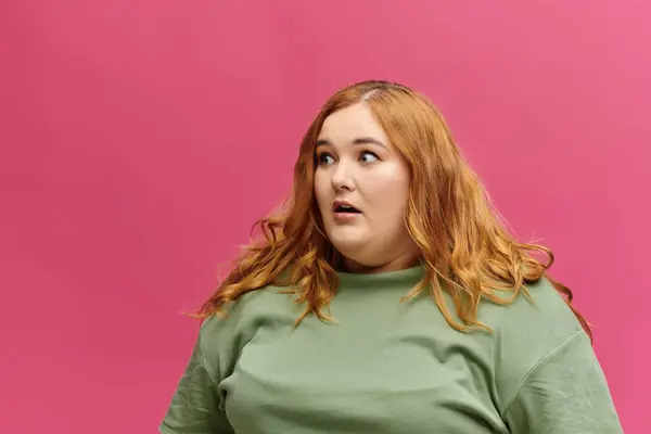 Uma mulher com uma camisola verde olha para o lado, surpreso. — Fotografia de Stock