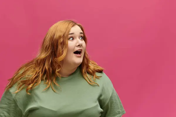 A woman with red hair and a surprised expression looks to her left. — Stock Photo