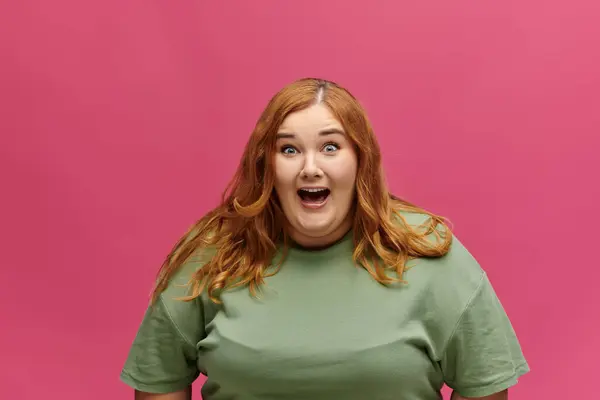 Red-haired woman in green shirt gasps in delight — Stock Photo