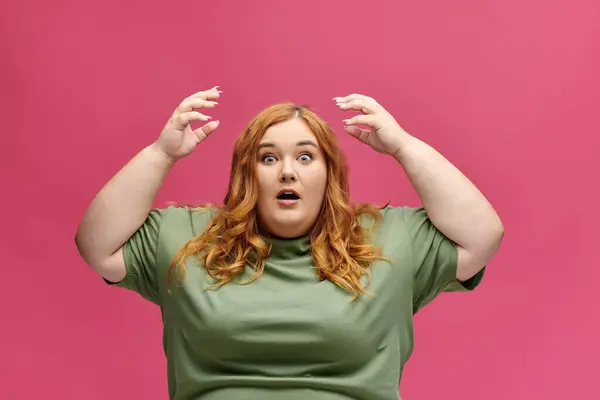 Roux courbée en tee-shirt vert, les mains levées en état de choc — Photo de stock