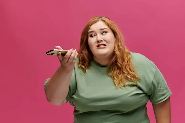 Plus-size woman, vibrant backdrop, determined expression, speaking on phone — Stock Photo