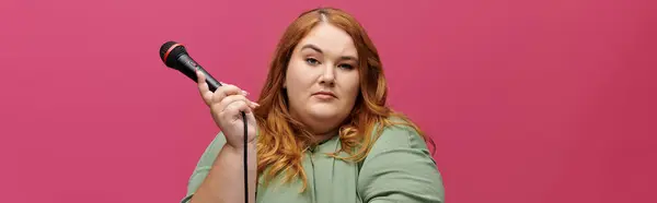 Una donna con i capelli castani e un'espressione sicura tiene un microfono. — Foto stock