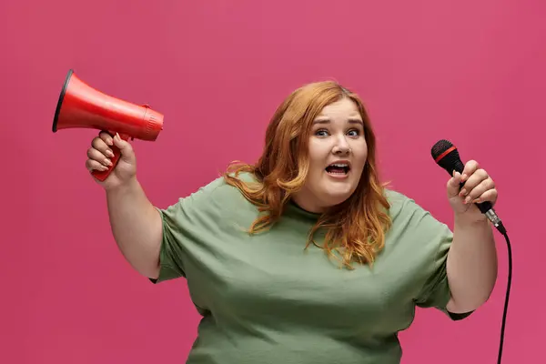 Eine selbstbewusste Frau hält Mikrofon und Megafon in der Hand, bereit, ihre Meinung zu sagen. — Stockfoto
