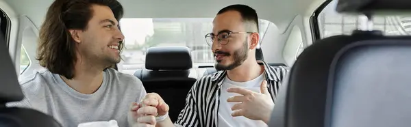 A gay couple shares a tender moment in the backseat of a car. — Stock Photo