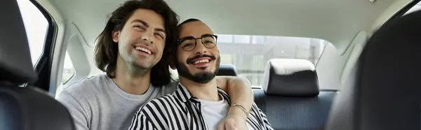 Two men laugh together in the backseat of a car. — Stock Photo