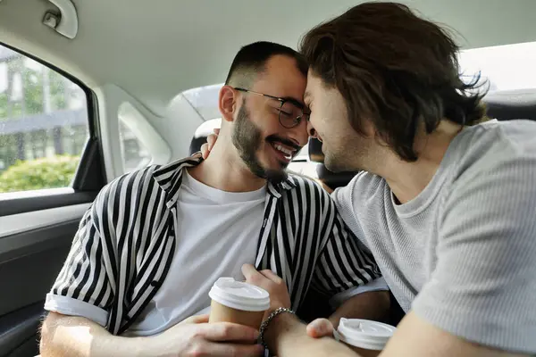 Two men embrace and share a moment of intimacy in the backseat of a car. — Stock Photo