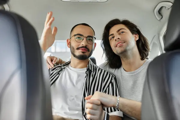 Two men in love hold hands in car — Stock Photo