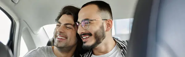 A loving gay couple smiles in the backseat of a car. — Stock Photo