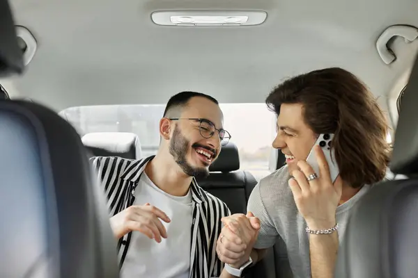 A gay couple in a car, laughing and holding hands, enjoying their time together. — Stock Photo