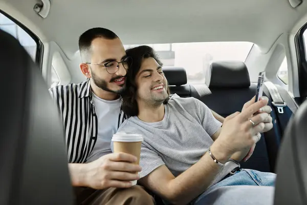Bonded couple in car, one on phone smiling, other holding coffee. — Stock Photo