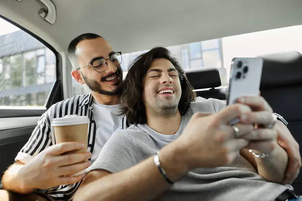 A gay couple laughs and enjoys each other's company in the backseat of a car. — Stock Photo