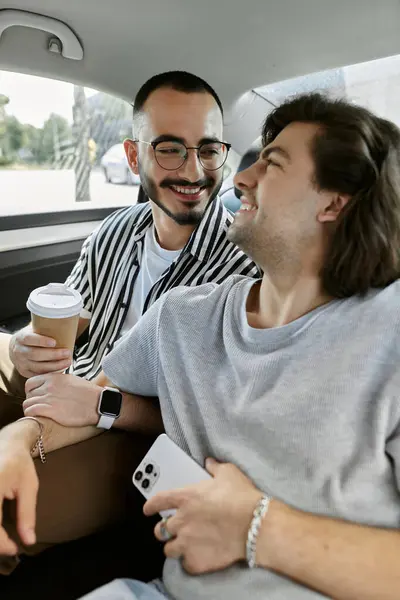 A gay couple shares a laugh while riding in a car. — Stock Photo
