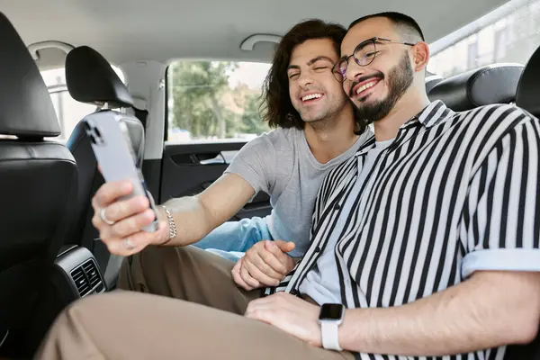 A gay couple takes a selfie together in the backseat of a car. — Stock Photo