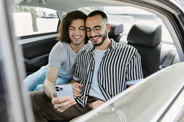 Two men take a selfie while sitting in the backseat of a car. — Stock Photo