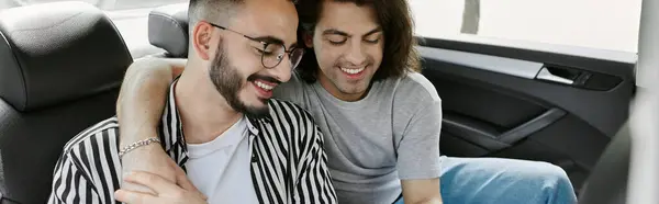 A gay couple shares a tender moment in the backseat of a car. — Stock Photo