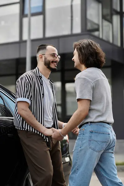 Dois homens dão as mãos e sorriem um para o outro enquanto caminham na cidade. — Stock Photo