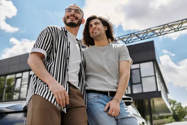 Two men stand close together in an urban setting, looking up and smiling. — Stock Photo